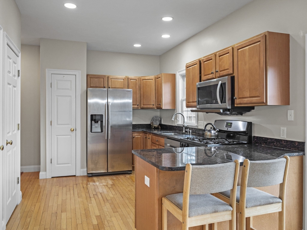 36 Knowlton Circle, Unit 1 Upton, MA 01568 - Photo 5 of 37 a kitchen with granite countertop a refrigerator stove microwave and cabinets
