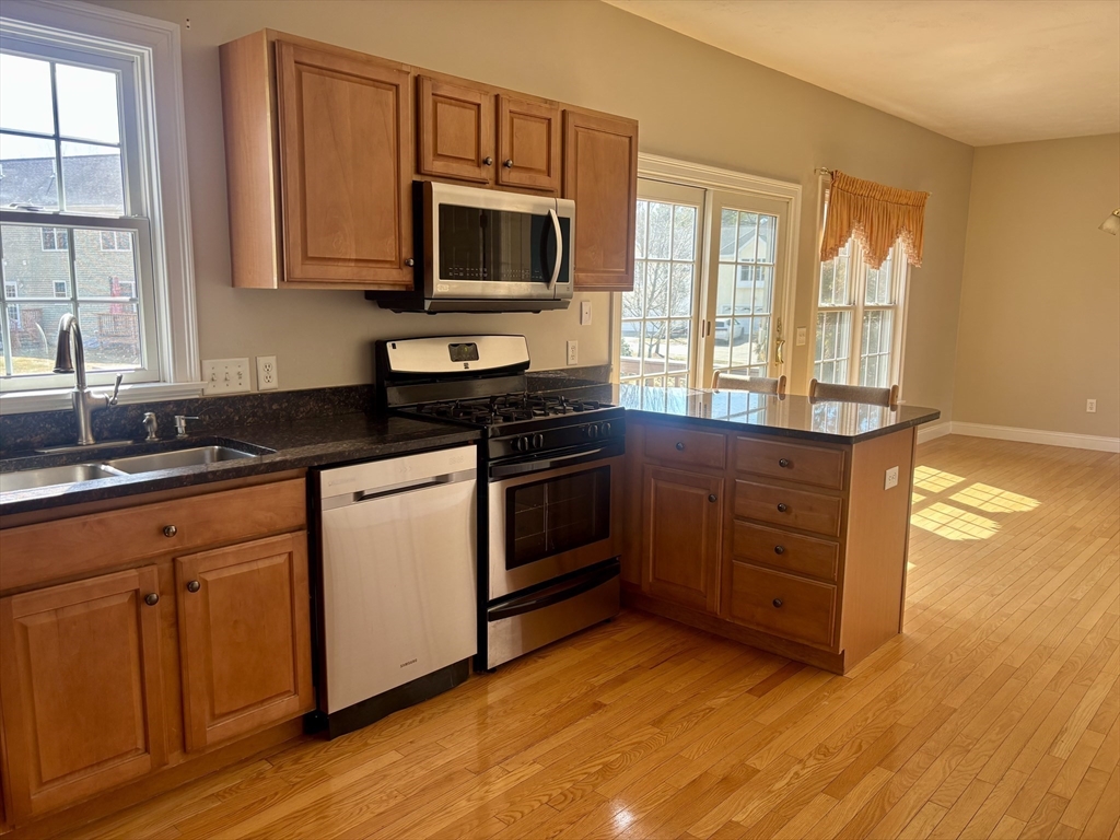 36 Knowlton Circle, Unit 1 Upton, MA 01568 - Photo 9 of 37 a kitchen with granite countertop a stove a sink and a microwave