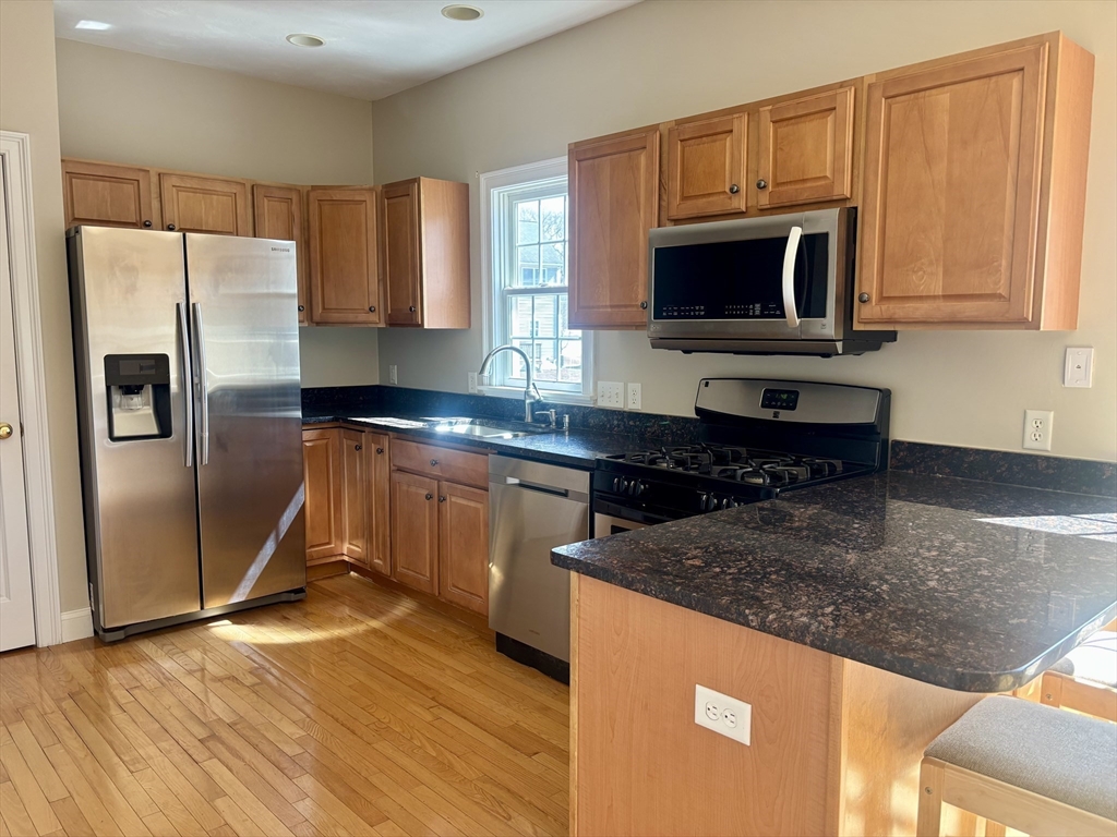 36 Knowlton Circle, Unit 1 Upton, MA 01568 - Photo 10 of 37 a kitchen with stainless steel appliances granite countertop a stove a sink and a microwave