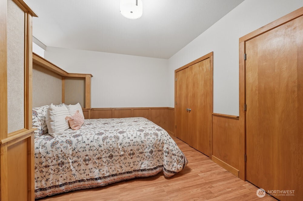 18013 West Snoqualmie Valley Road Northeast Duvall, WA 98019 - Photo 13 of 40 a bedroom with a large bed and wooden floor