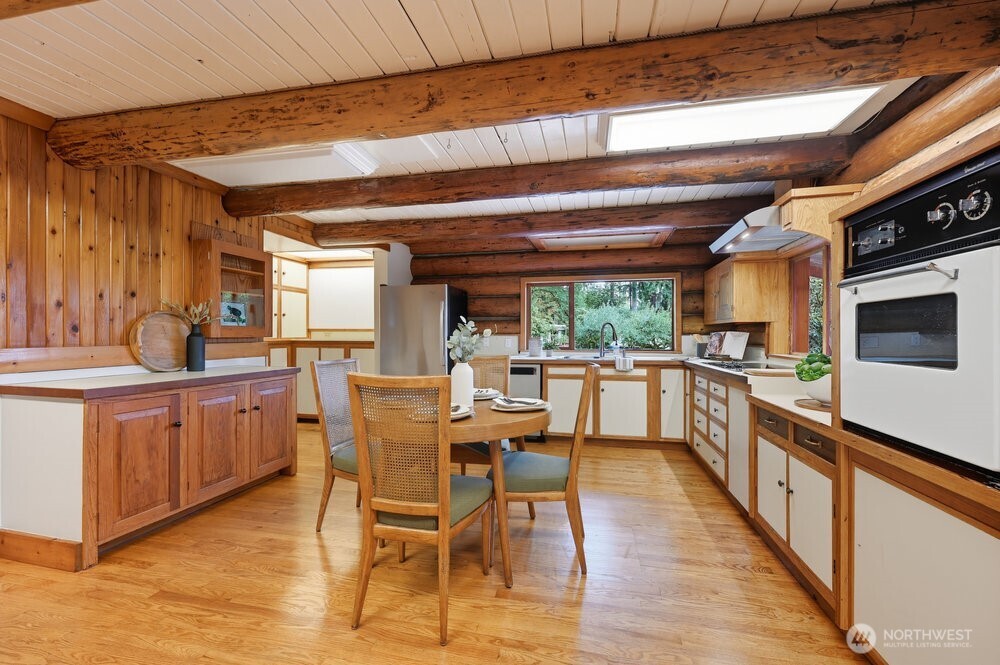 18013 West Snoqualmie Valley Road Northeast Duvall, WA 98019 - Photo 23 of 40 a kitchen with stainless steel appliances kitchen island granite countertop a table chairs in it and wooden floors
