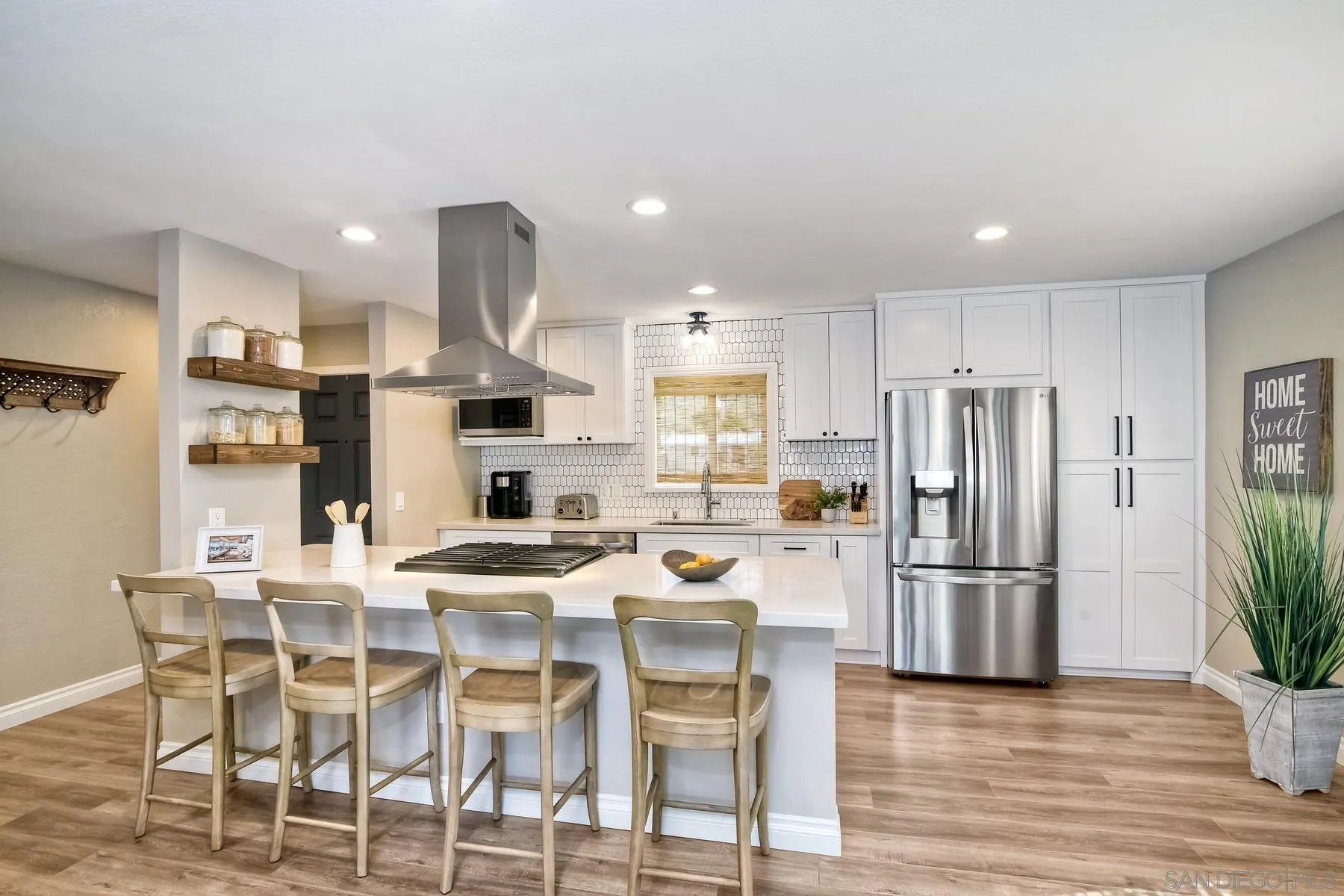13748 Tobiasson Road Poway, CA 92064 - Photo 4 of 18 a kitchen with stainless steel appliances kitchen island granite countertop a refrigerator and a stove top oven