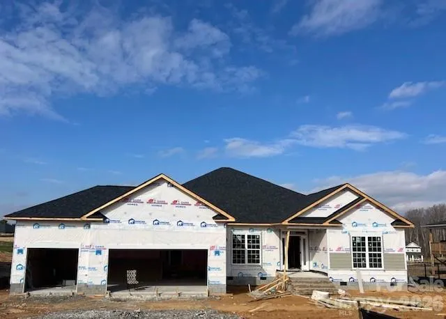 a view of a big house with wooden fence