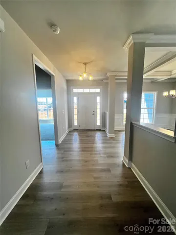 a view of a hallway with furniture and wooden floor