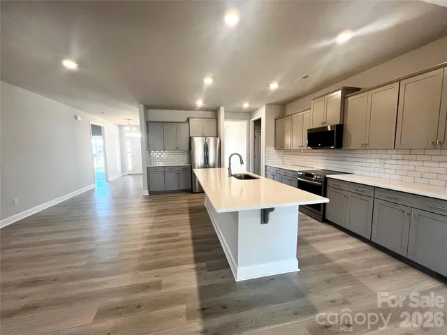 a large kitchen with stainless steel appliances lots of counter space and wooden floor