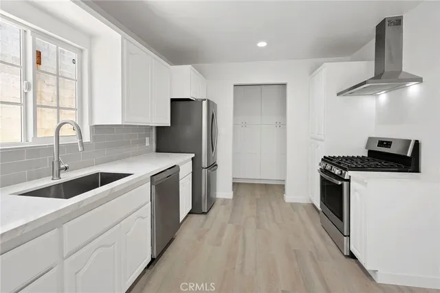a kitchen with stainless steel appliances granite countertop a sink a stove and a refrigerator