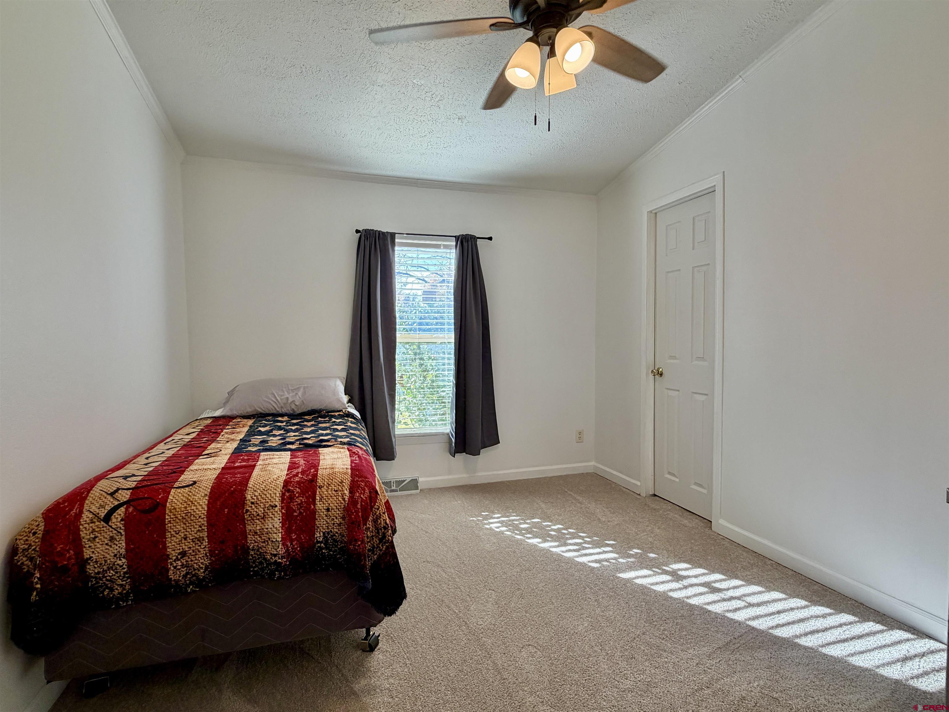 650 1725th Road Delta, CO 81416 - Photo 28 of 45 a bedroom with a bed and a chandelier
