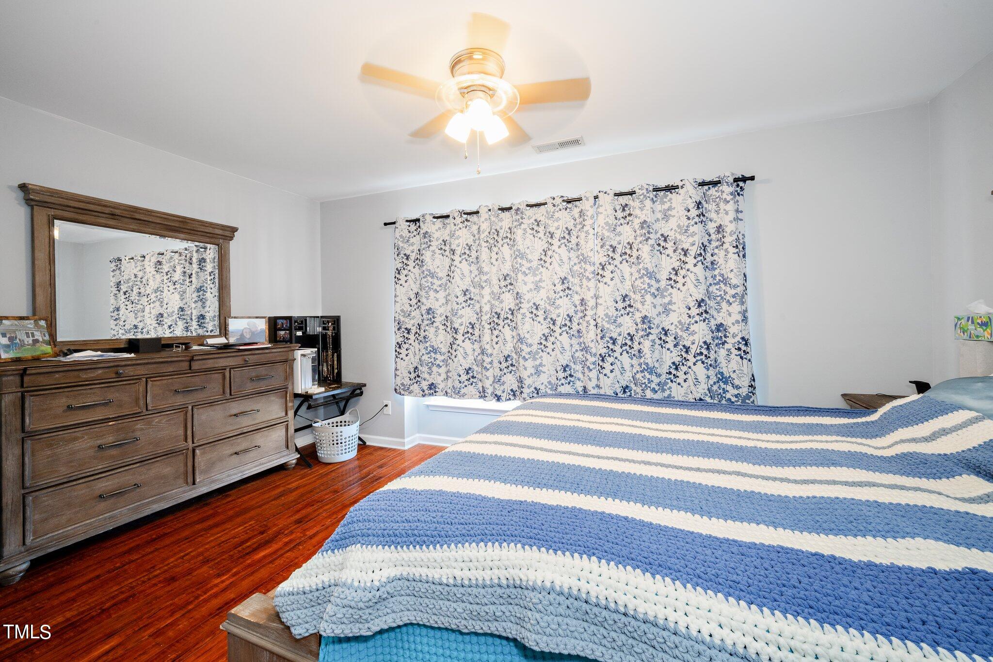 9813 Cicero Drive Raleigh, NC 27617 - Photo 15 of 21 a bedroom with a bed and a chandelier