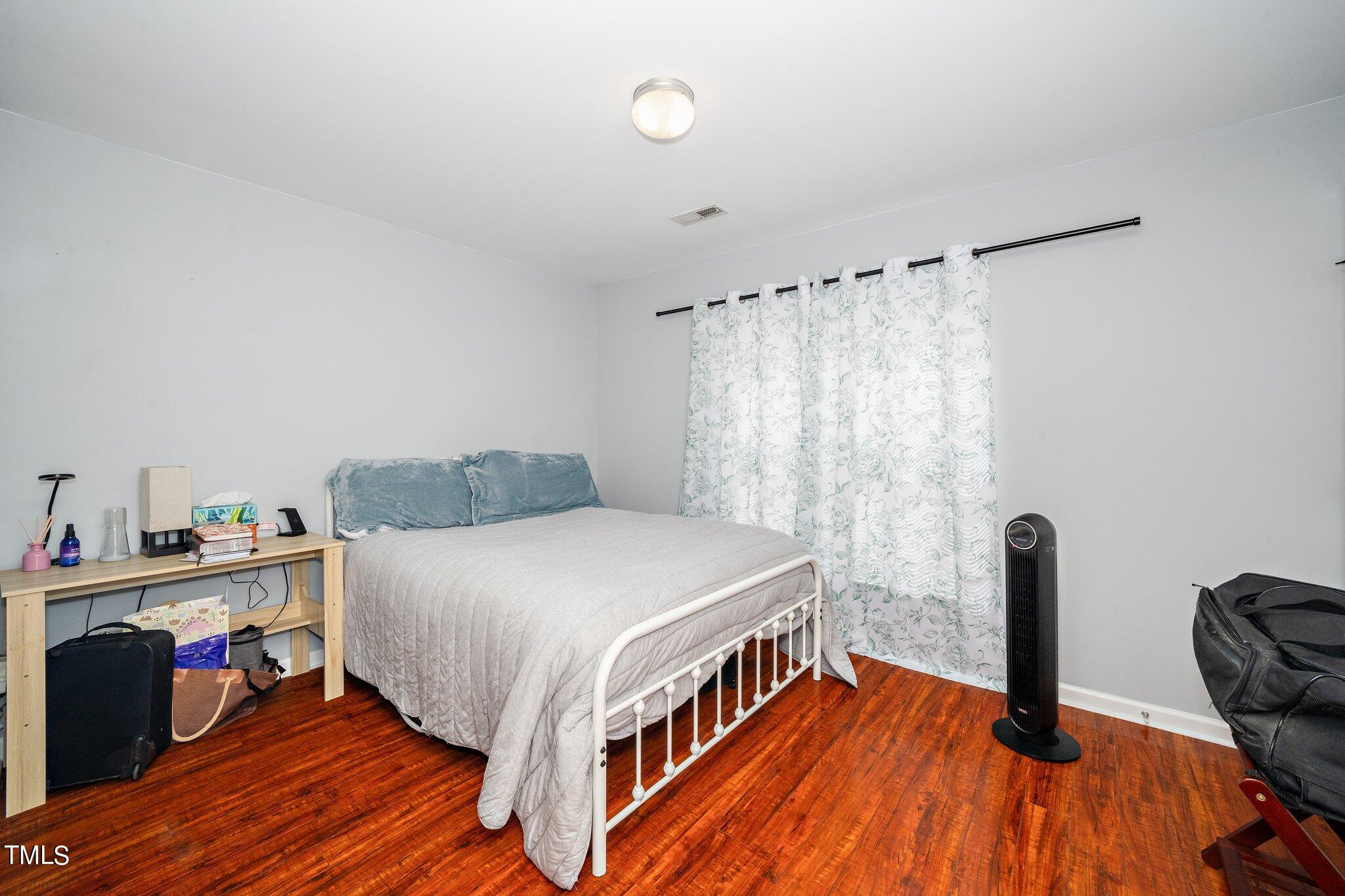9813 Cicero Drive Raleigh, NC 27617 - Photo 17 of 21 a bedroom with a bed and a wooden floor