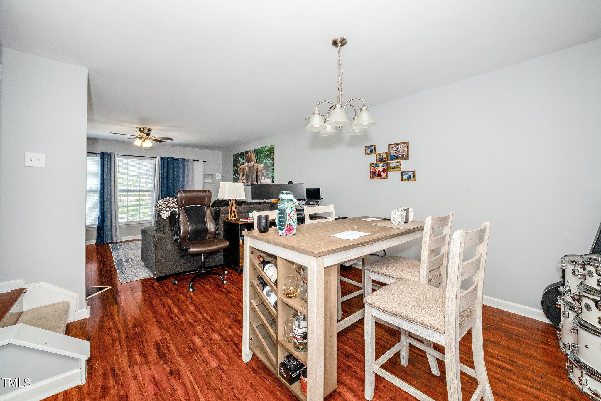 9813 Cicero Drive Raleigh, NC 27617 - Photo 7 of 21 a view of a dining room with furniture a chandelier and wooden floor