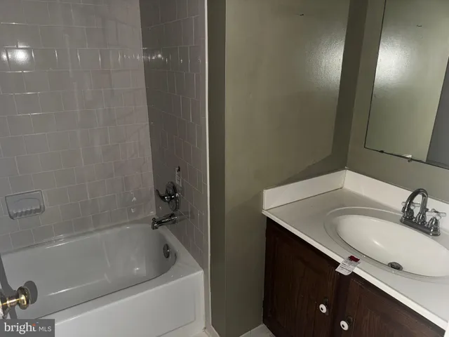a bathroom with a granite countertop sink a toilet and bathtub