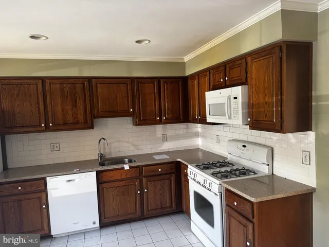 a kitchen with stainless steel appliances a stove a sink and a refrigerator with wooden cabinets