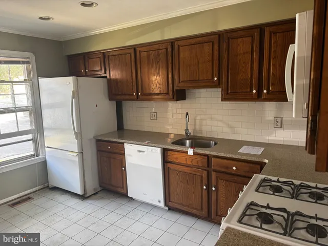 a kitchen with stainless steel appliances granite countertop a refrigerator stove and sink