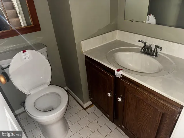 a bathroom with a granite countertop toilet sink and mirror