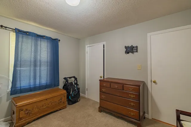 a bedroom with a bed and dresser with mirror