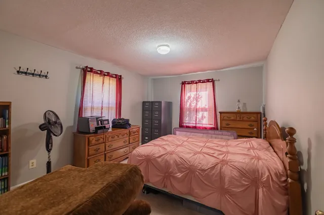 a bed sitting in a bedroom next to a window