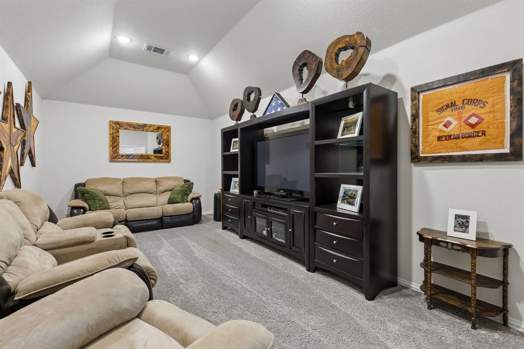 1023 Ridgehurst Road Melissa, TX 75454 - Photo 28 of 39 Spacious room featuring vaulted ceilings with recessed lighting, light gray carpeting, and a built-in media center with shelving and storage drawers