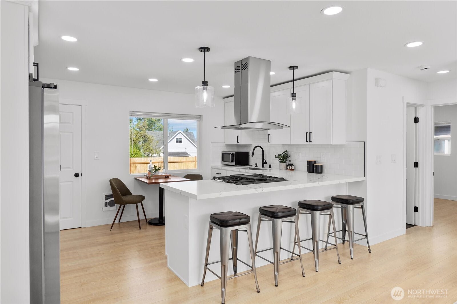 763 Edmonds Avenue Northeast Renton, WA 98056 - Photo 13 of 26 a kitchen with stainless steel appliances kitchen island a table and chairs in it