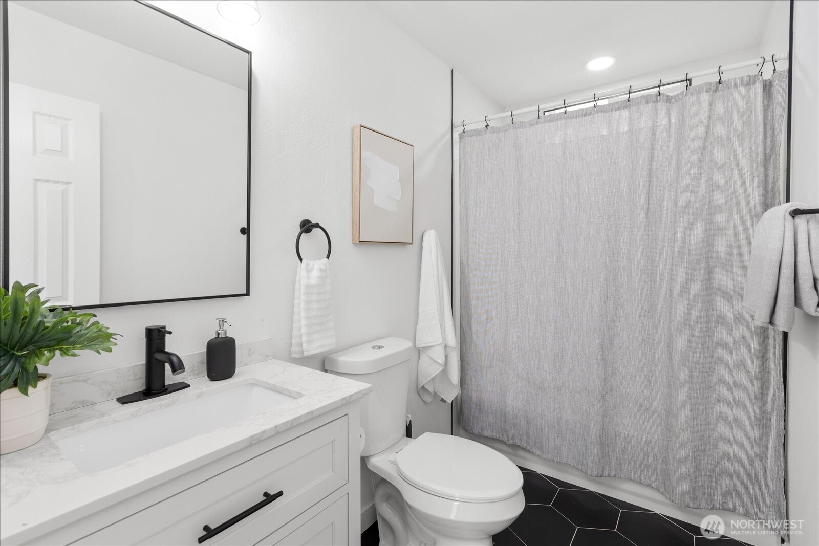 763 Edmonds Avenue Northeast Renton, WA 98056 - Photo 7 of 26 a bathroom with a sink a toilet a mirror and shower curtain