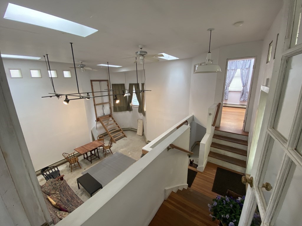 26 Tower Street Boston, MA 02130 - Photo 15 of 17 a room with lots of white furniture and a chandelier