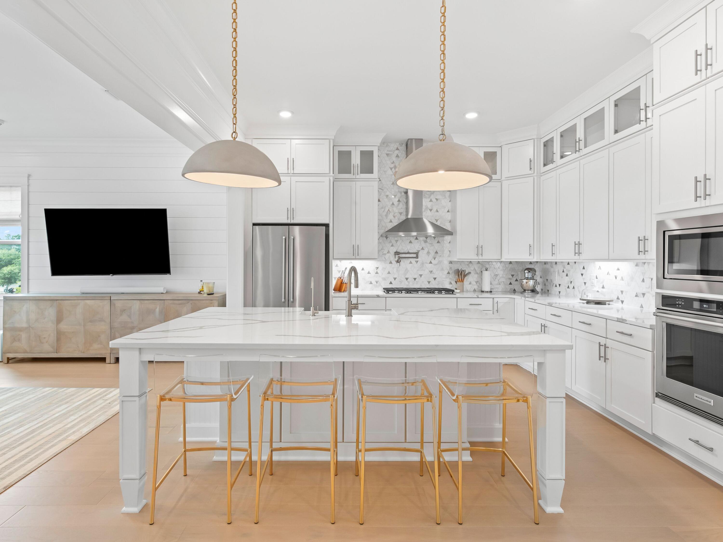 125 Seaboard Lane Santa Rosa Beach, FL 32459 - Photo 6 of 49 a kitchen with stainless steel appliances kitchen island granite countertop a stove a sink and a dining table with white cabinets