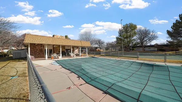 a view of swimming pool in front of residential houses with yard