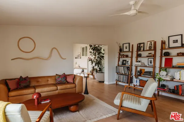 a living room with furniture a rug and a book shelf