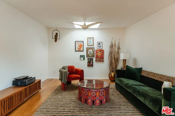 a living room with furniture a rug and a book shelf