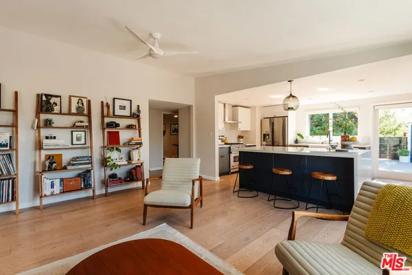 a living room with furniture a rug and a bookshelf