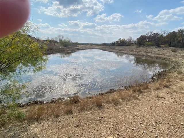 a view of a lake with beach and background