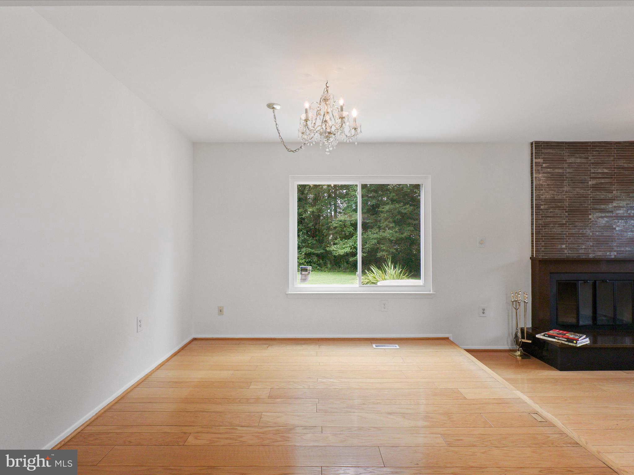 5922 Hall Street Springfield, VA 22152 - Photo 13 of 47 an empty room with a fireplace and a chandelier