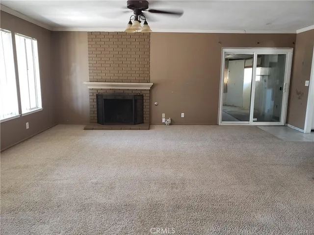 an empty room with windows and fireplace