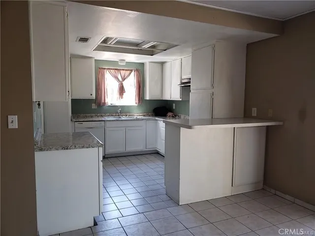 a kitchen with a sink window and cabinets