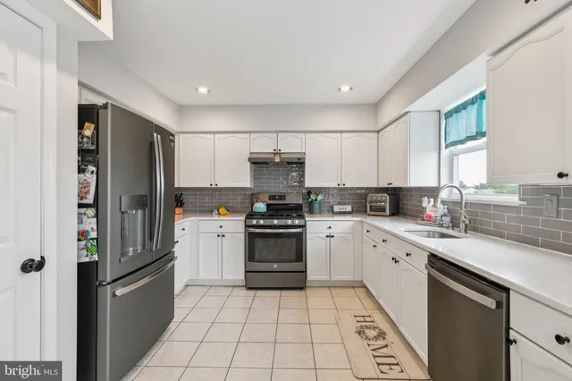 a kitchen with a sink a refrigerator and cabinets
