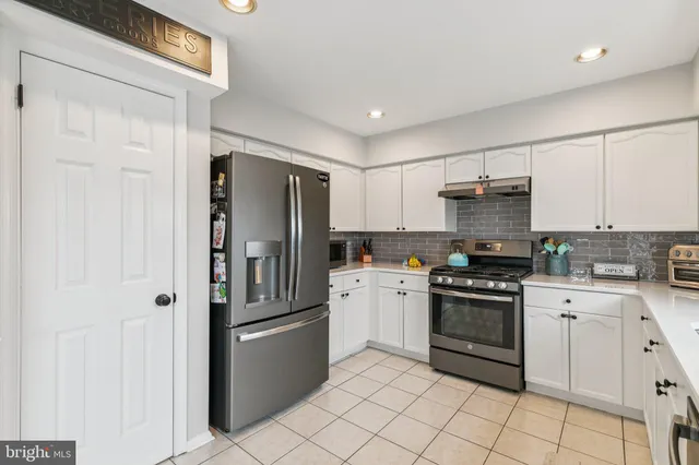 a kitchen with stainless steel appliances granite countertop a refrigerator sink and stove