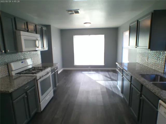 a kitchen with stainless steel appliances granite countertop a stove a sink and a refrigerator