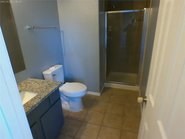 a bathroom with a granite countertop toilet and a sink