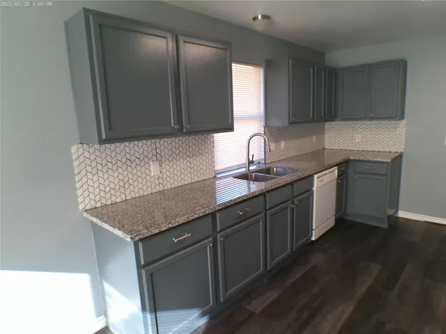 a kitchen with a sink refrigerator and cabinets