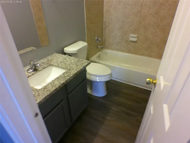a bathroom with a granite countertop sink toilet and shower