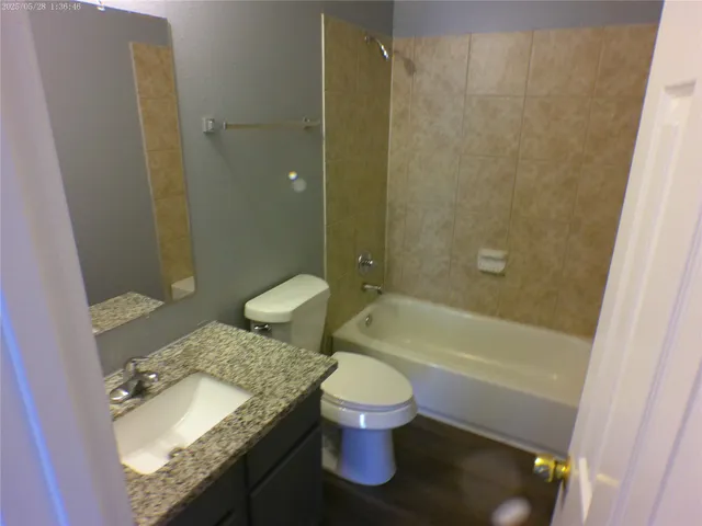 a bathroom with a granite countertop sink toilet and shower