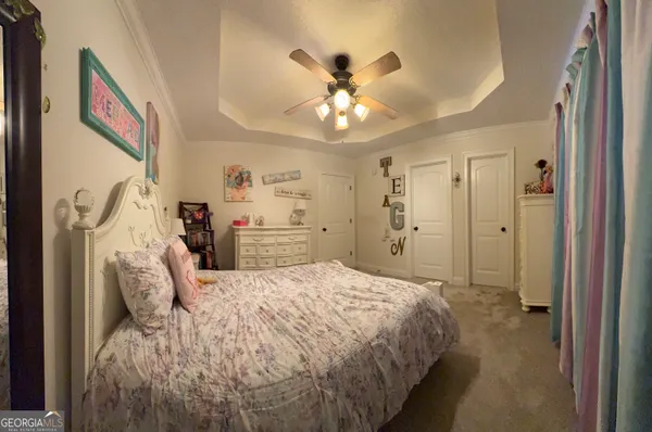 a spacious bedroom with a bed and a chandelier