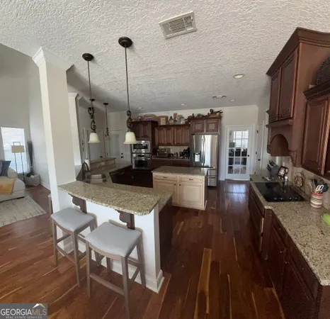 a kitchen with sink refrigerator and wooden floor