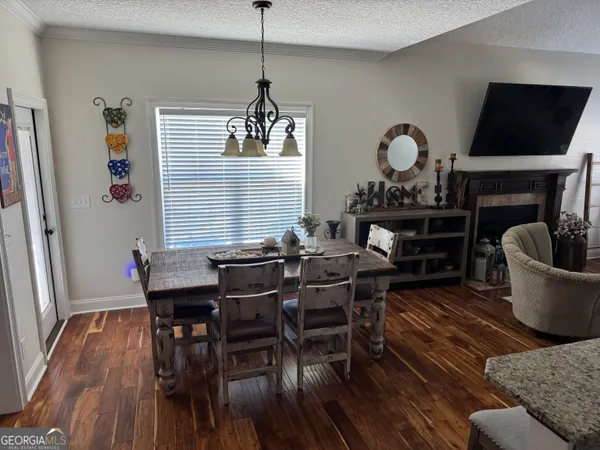 a dining room with furniture a chandelier and wooden floor