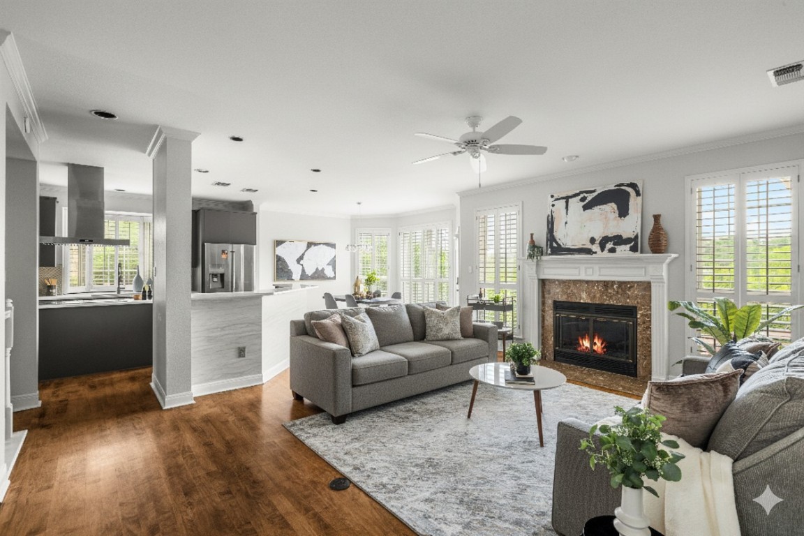 2807 Round Table Road Austin, TX 78746 - Photo 9 of 38 Living area featuring crown molding, dark wood-style flooring, a premium fireplace, and a ceiling fan