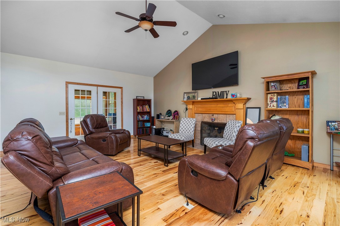 177 Mishler Road Mogadore, OH 44260 - Photo 5 of 50 Living room featuring, lighter hardwood flooring, high vaulted ceiling, french doors to three season room, and a fireplace view looking from foyer/ main entrance