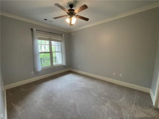 an empty room with a window and a fan