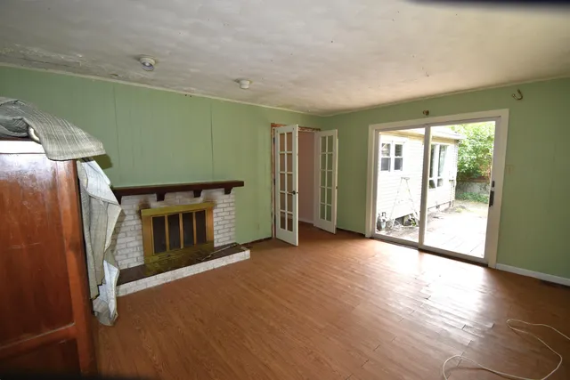 a view of a livingroom with wooden floor and a fireplace