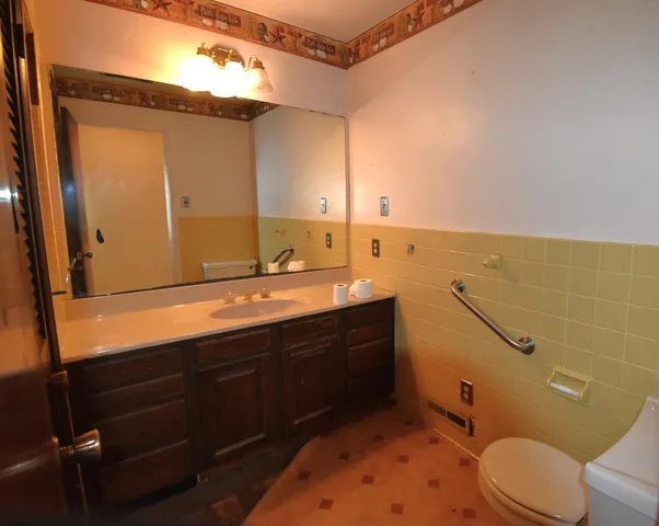 a bathroom with a sink mirror vanity and toilet
