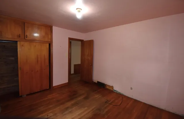an empty room with wooden floor and closet