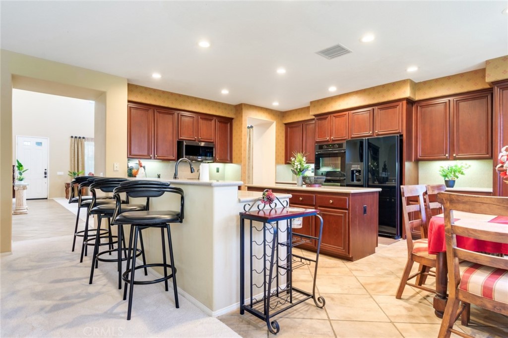 2967 Mangular Avenue Corona, CA 92882 - Photo 13 of 37 a kitchen with stainless steel appliances kitchen island granite countertop a refrigerator and a stove top oven